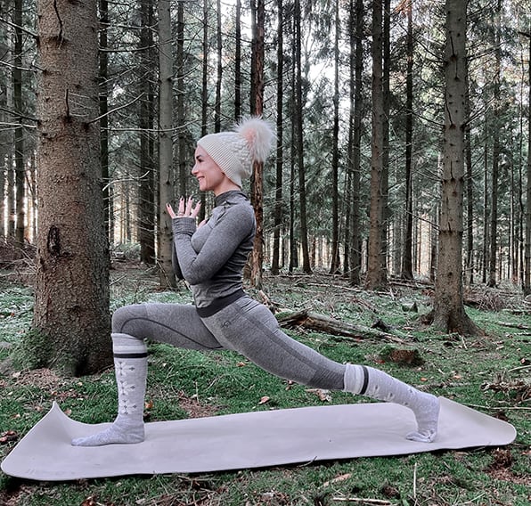 Coach laver yoga i skoven.